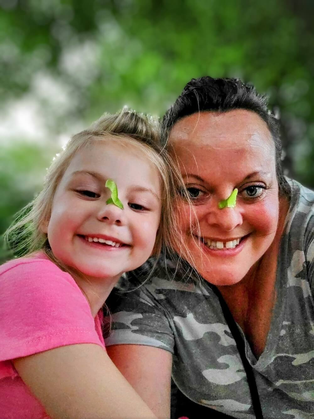 heather with a child both with green helicopter seeds stuck to their noses